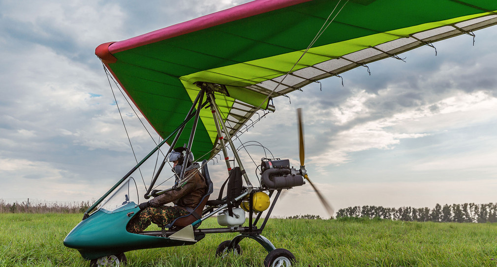 Ein Ultraleichtflugzeug steht auf einem Flugfeld.