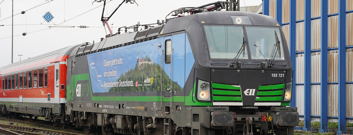 Ein Zug mit der Beschriftung "Zügiger geht´s nicht: der schnellste Regionalverkehr in Deutschland" sthet auf Bahngleisen.