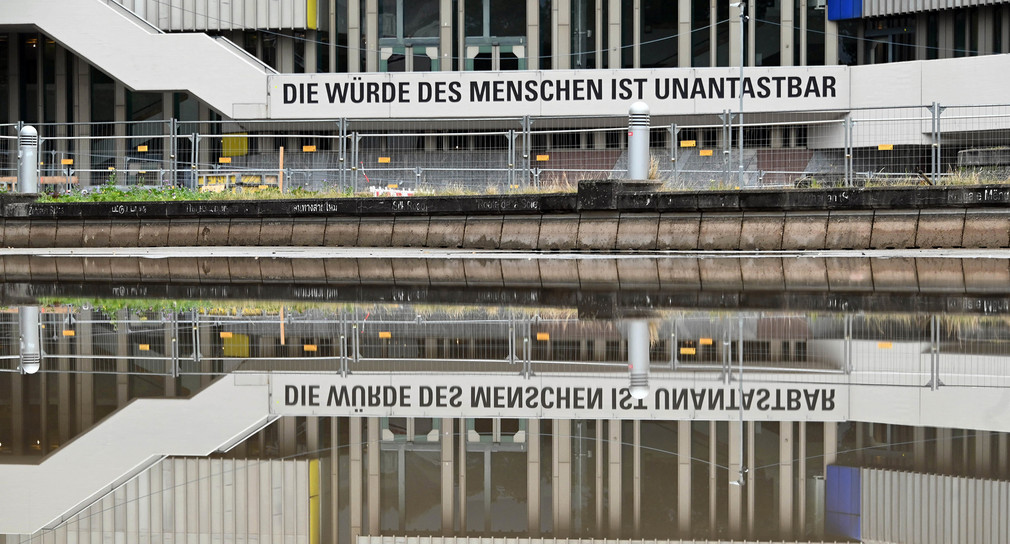 Außenaufnahme des Badischen Staatstheaters in Karlsruhe, das sich in einer Wasserfläche spiegelt. (Bild: picture alliance/Uli Deck/dpa)