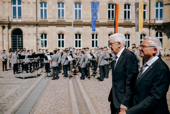 Ministerpräsident Winfried Kretschmann und der stellvertretende Ministerpräsident (Zweiter von rechts) und Innenminister Thomas Strobl (rechts), im Hintergrund das Heeresmusikkorps Ulm der Bundeswehr