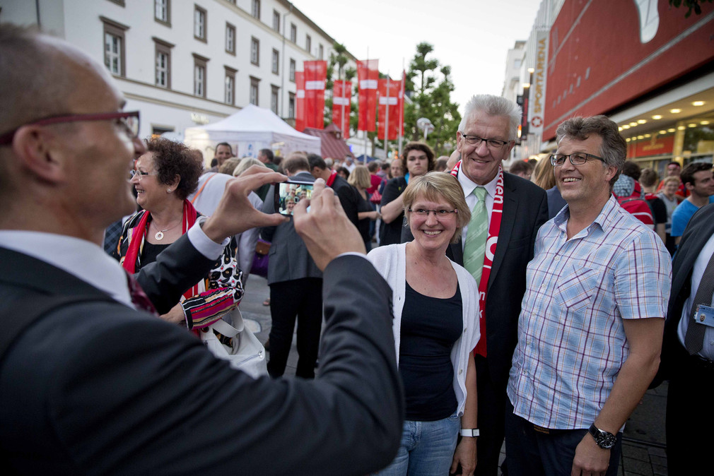 Ministerpräsident Winfried Kretschmann (2.v.r.) lässt sich mit Besuchern des Kirchentags fotografieren.