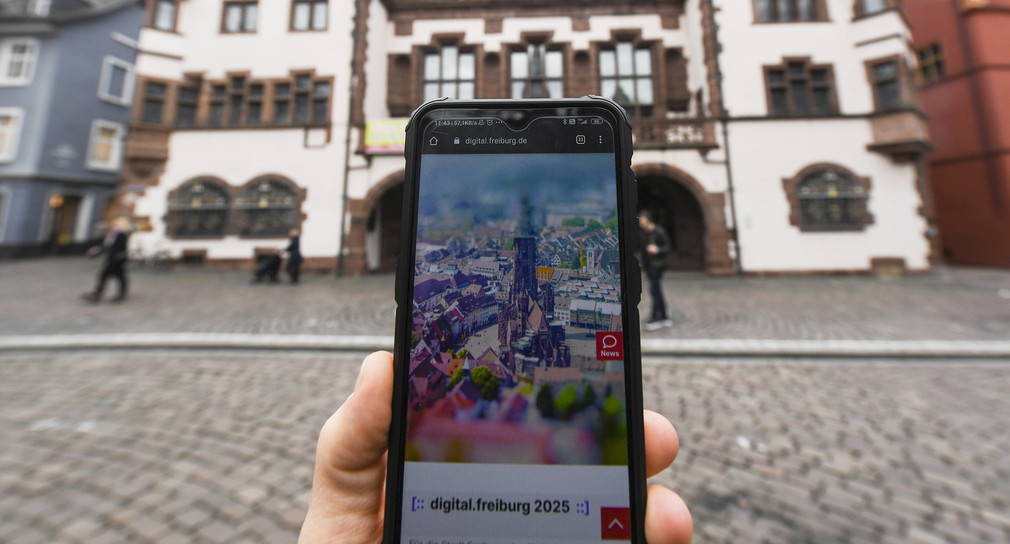 Auf einem Smartphone vor dem Rathaus ist die Webseite „Digital.freiburg.de“ geöffnet. (Bild: picture alliance/Patrick Seeger/dpa)