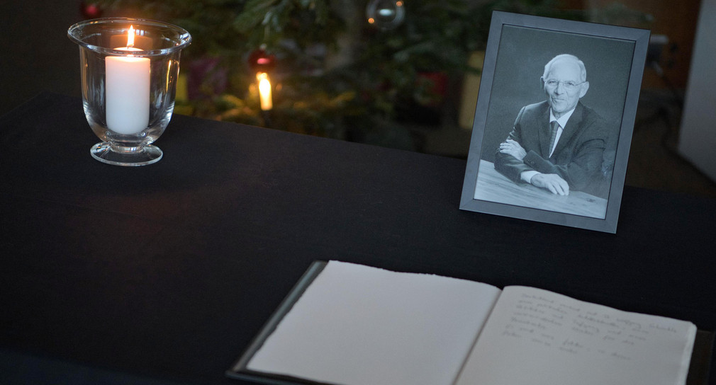 Ein Kondolenzbuch für den verstorbenen Politiker Wolfgang Schäuble liegt auf einem Tisch in der Landesvertretung von Baden-Württemberg. Auch ein Foto des CDU-Politikers ist zu sehen.