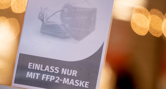 Ein Schild auf der Eingangstür eines Einzelhandelsgeschäfts weist auf das Tragen einer FFP2-Maske hin.