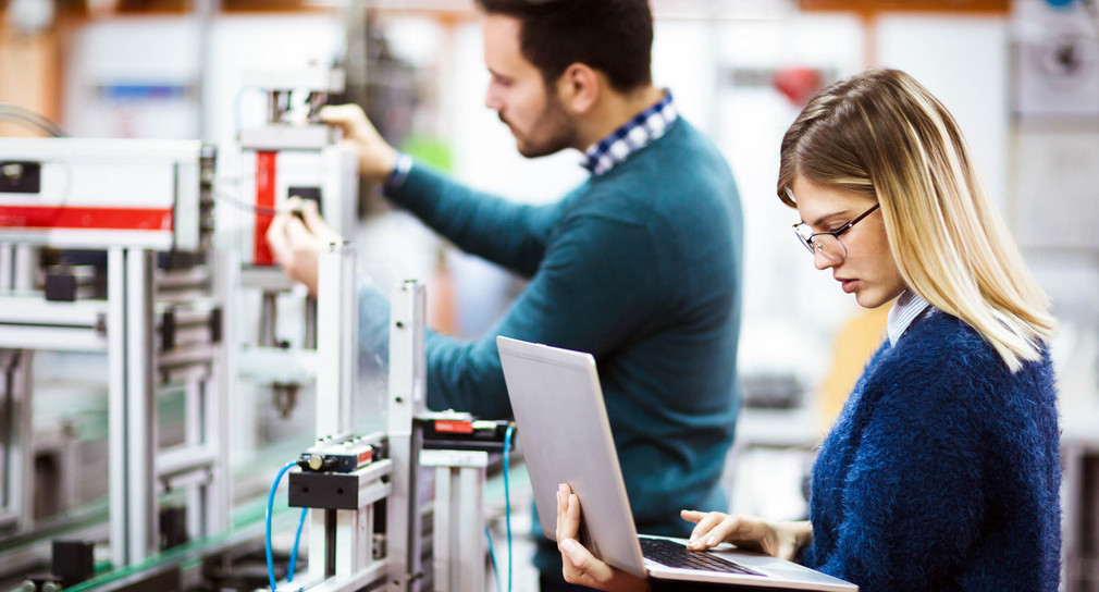 Eine Studentin und ein Student der Elektrotechnik arbeiten an einem Projekt.