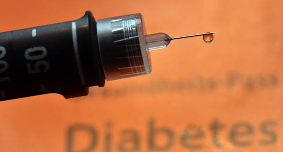 Ein Tropfen Insulin hängt an Nadel einer wiederverwendbaren Spritze, einem so genannten Pen.