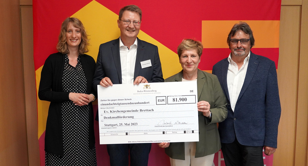 Symbolische Scheckübergabe im Rahmen der Denkmalförderung an die Evangelische Kirchengemeinde Brettach; von links: Isabell Huber MdL; Pfarrer Christoph Heinritz; Nicole Razavi MdL, Ministerin für Landesentwicklung und Wohnen; Armin Waldbüßer MdL