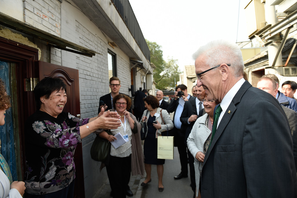 Ministerpräsident Winfried Kretschmann (r.) besucht ein Hutong