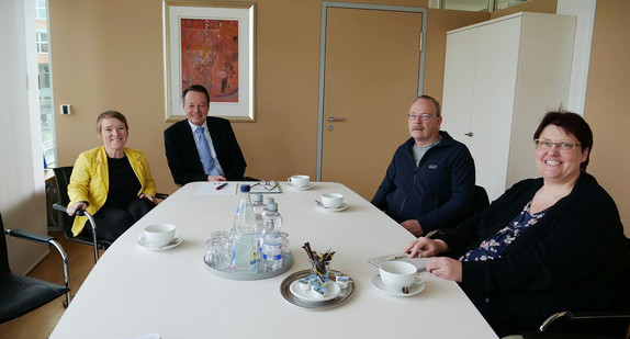 Simone Fischer, Klaus Tappeser (Präsident beim RP Tübingen), Thomas Vogel und Yvonne Straub (Vertrauenspersonen der schwerbehinderten Mitarbeitenden) sitzen an einem Tisch in einem Konferenzraum.
