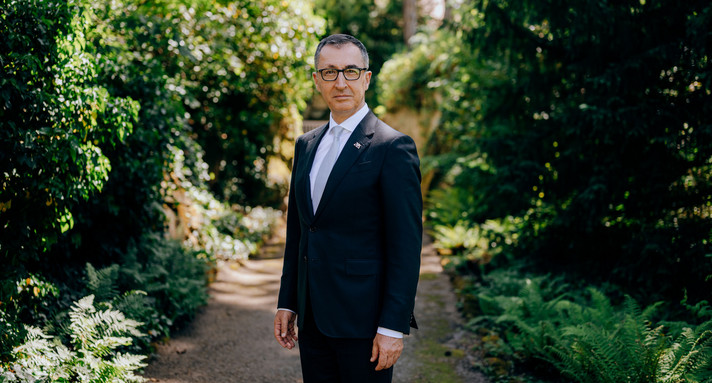 Portraitbild von Ministerpräsident Cem Özdemir, stehend im Park der Villa Reitzenstein.