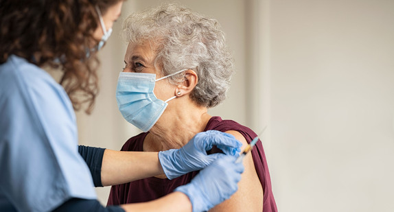 Eine ältere Dame erhält eine Impfung.