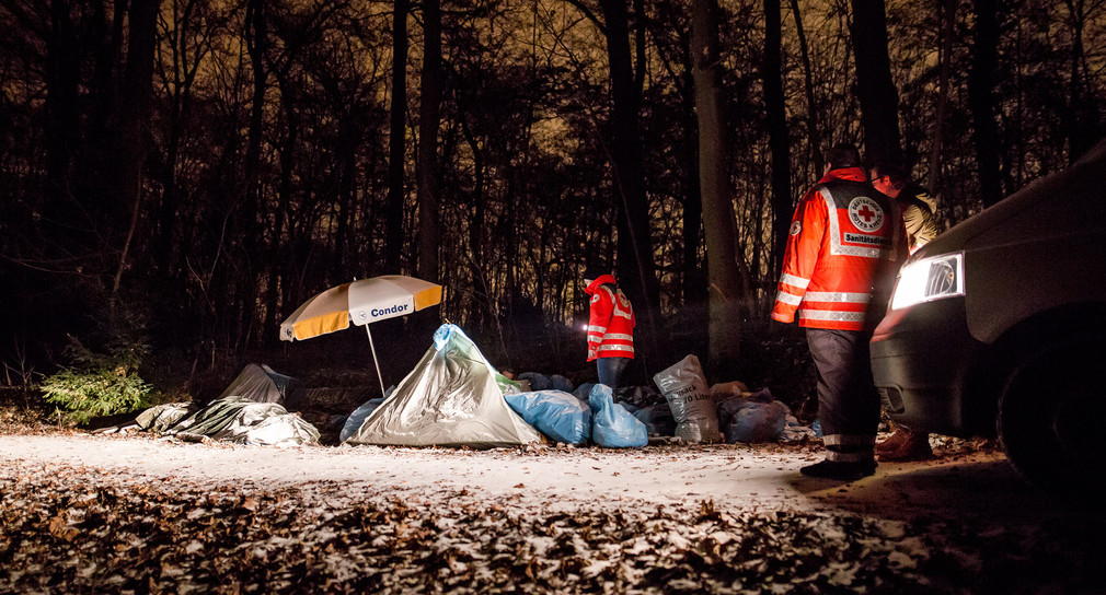 Ehrenamtliche Mitarbeiter vom Deutschen Roten Kreuz (DRK) und Teil des Teams vom Kältebus schauen am frühen Morgen des 8. Januar 2017 nach einem 87-jährigen Obdachlosen, der im Kräherwald in Stuttgart lebt. (Bild: picture alliance/Christoph Schmidt/dpa)