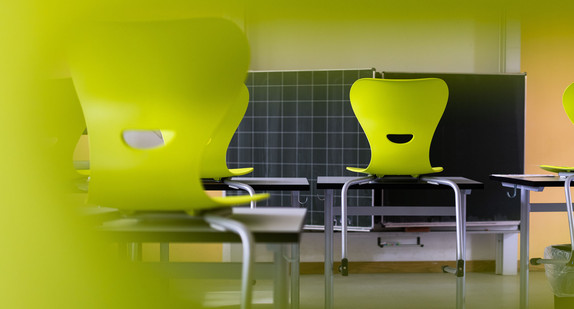 Stühle stehen auf Tischen in einem leeren Klassenzimmer einer Realschule.