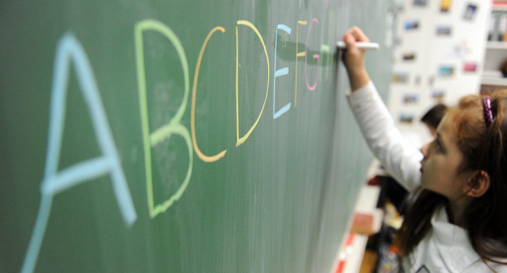 Eine Schülerin einer zweiten Klasse schreibt in einer Schule das ABC an die Tafel. (Foto: dpa)