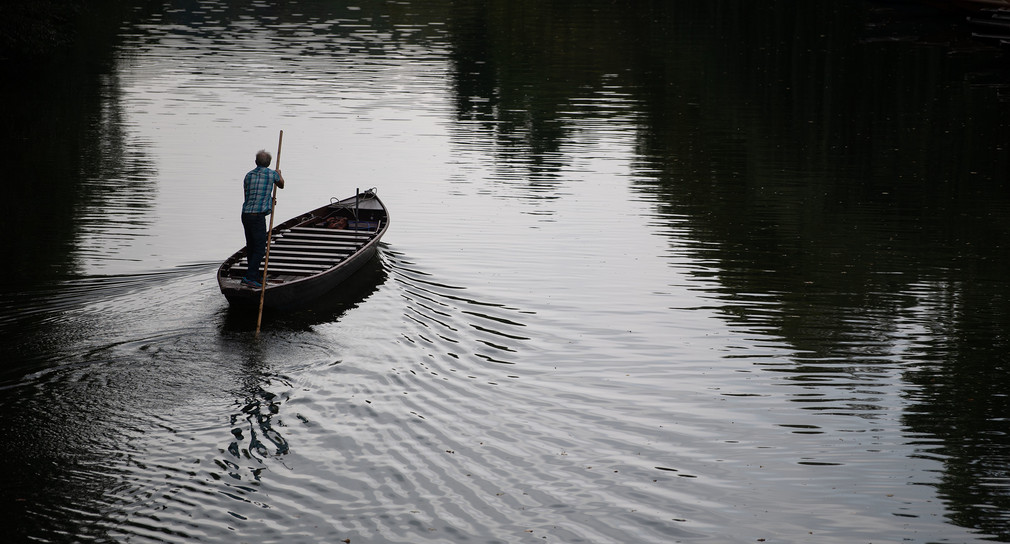 Ein Mann fährt auf dem Neckar bei Tübingen mit einem Stocherkahn. (Bild: picture alliance/Marijan Murat/dpa)