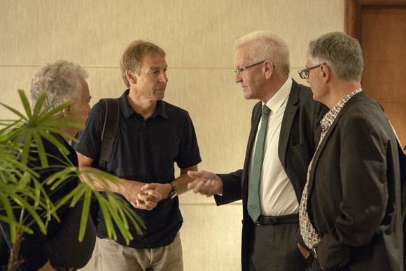 Delegationreise Kretschmann reist nach Kalifornien und Ontario v.l.n.r.: Prof. Hans Ulrich Gumbrecht, Jürgen Klinsmann, Ministerpräsident Winfried Kretschmann und Arne Braun, stellvertretender Regierungssprecher (Foto: Staatsministerium Baden-Württemberg)
