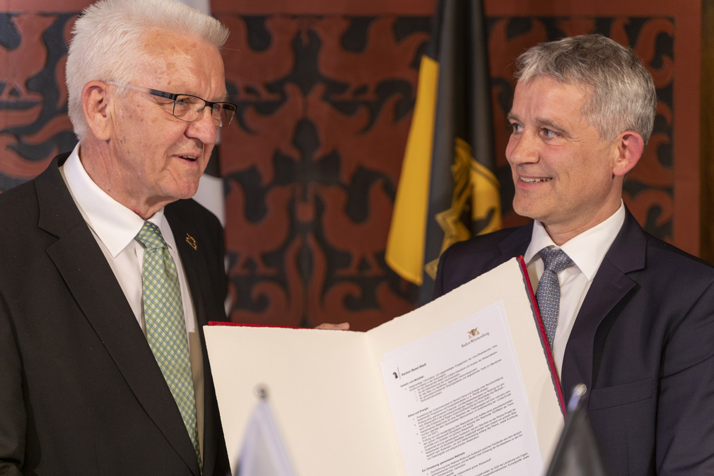 Ministerpräsident Winfried Kretschmann (links) und Regierungspräsident Beat Jans (rechts) mit der Gemeinsamen Absichtserklärung zur Zusammenarbeit zwischen Baden-Württemberg und Basel-Stadt in Zukunftsbereichen.