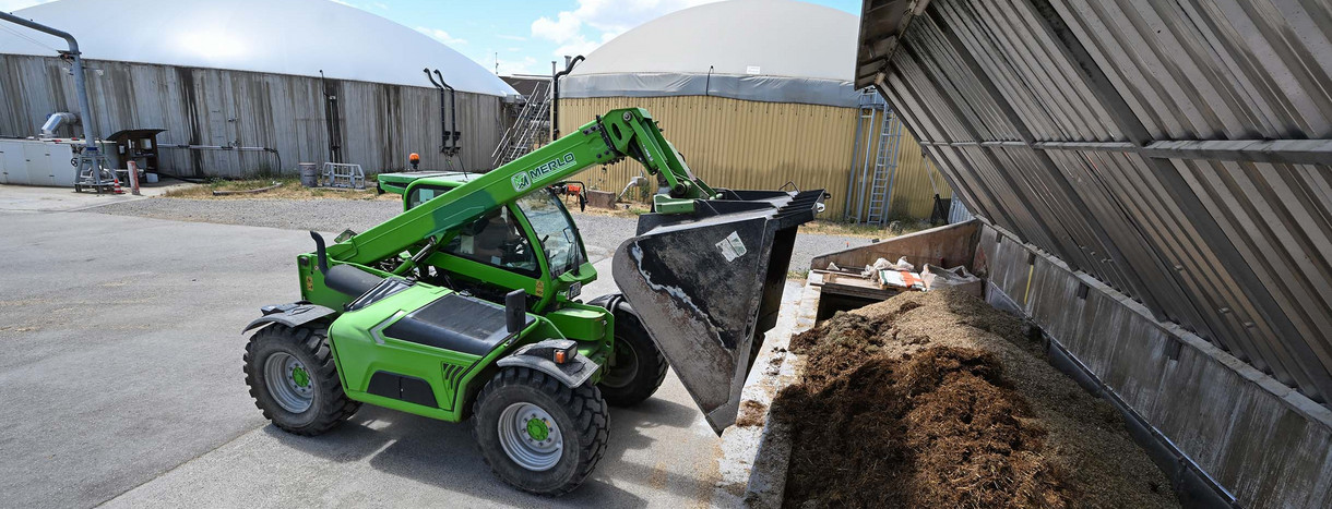 Ein Mitarbeiter einer Biogasanlage von Naturenergie Glemstal befüllt die Anlage mit Biomasse.