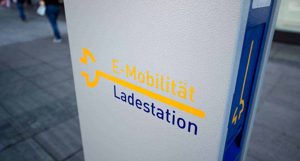 Eine Elektrotankstelle mit der Aufschrift „E-Mobilität - Ladestation“ (Quelle: © dpa).