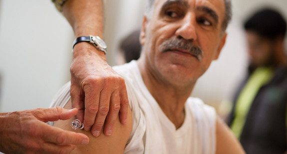 Ein Mann bekommt eine Impfung in den Oberarm.