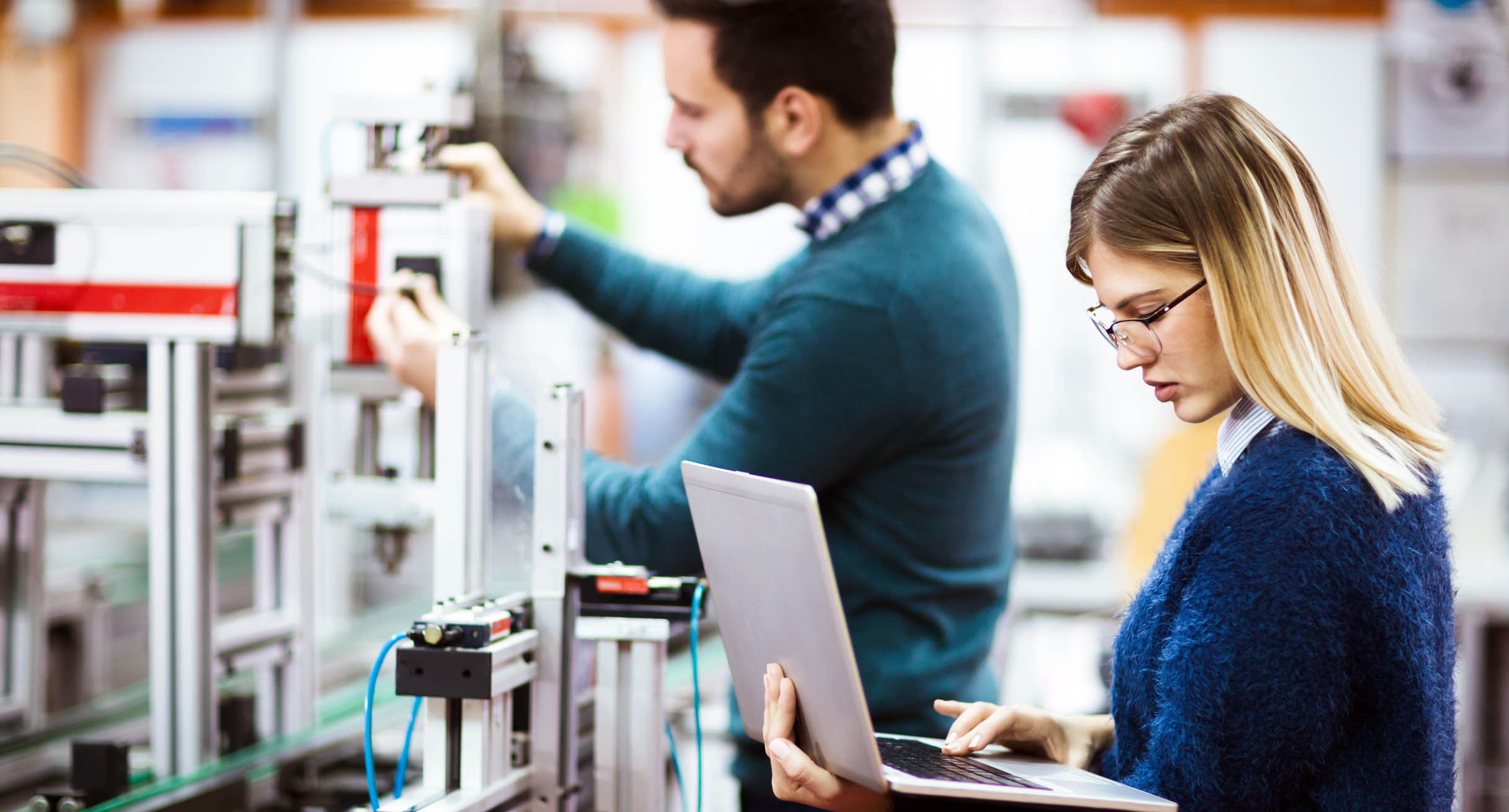 Eine Studentin und ein Student der Elektrotechnik arbeiten an einem Projekt.']