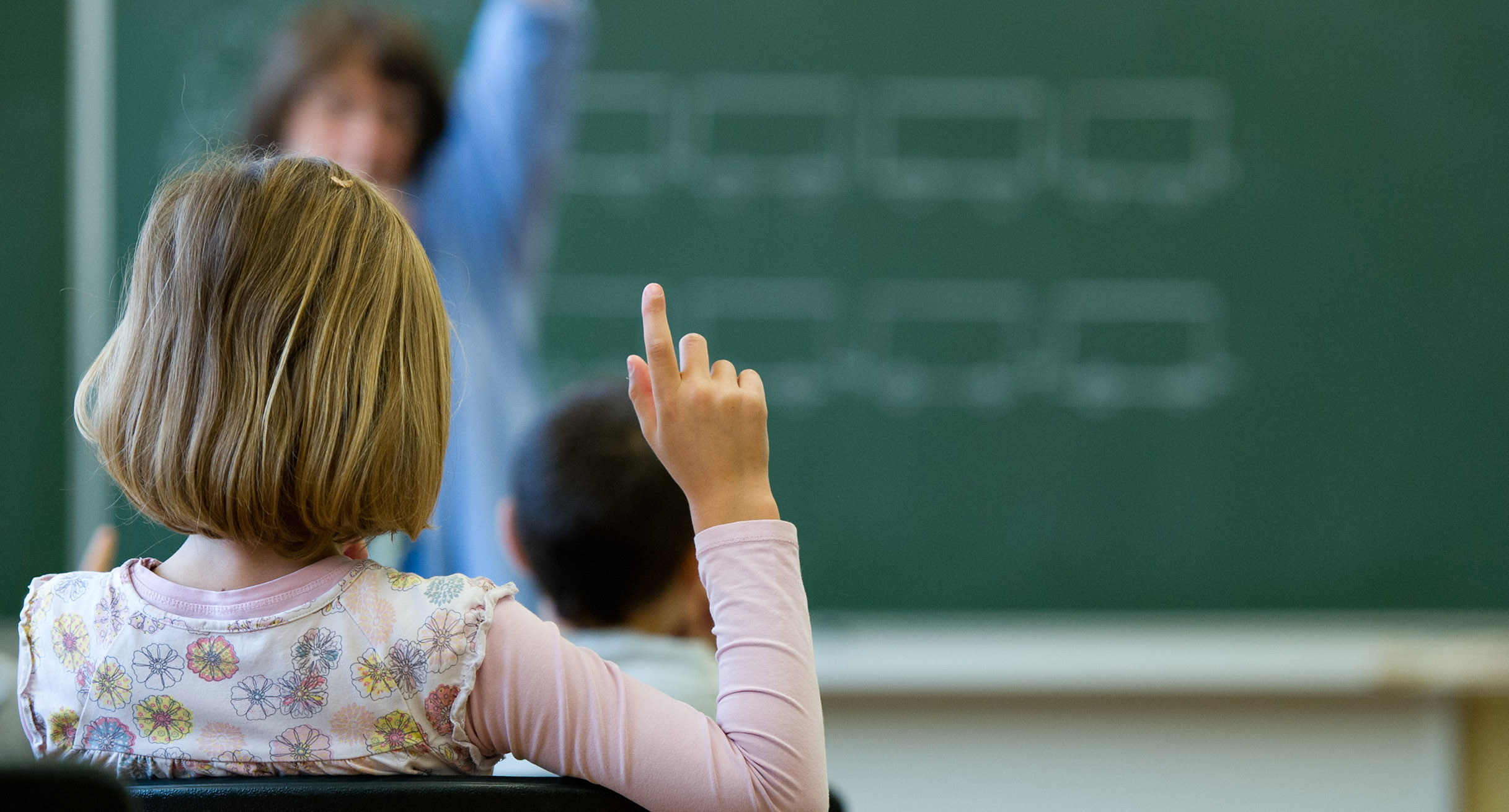 Eine Schülerin meldet sich in einer Schule in Stuttgart während des Unterrichts.']