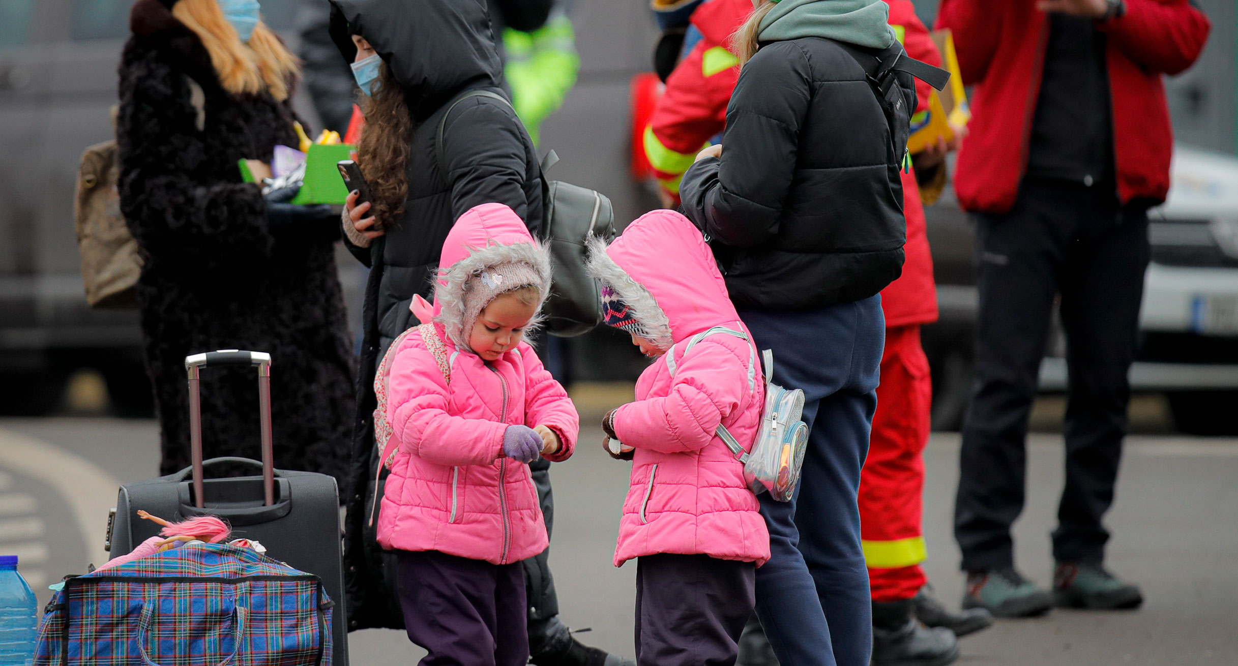 Ukrainische Kinder öffnen an der rumänisch-ukrainischen Grenze Süßigkeiten, die sie von Freiwilligen erhalten haben, nachdem sie vor dem Konflikt in der benachbarten Ukraine geflohen sind.']