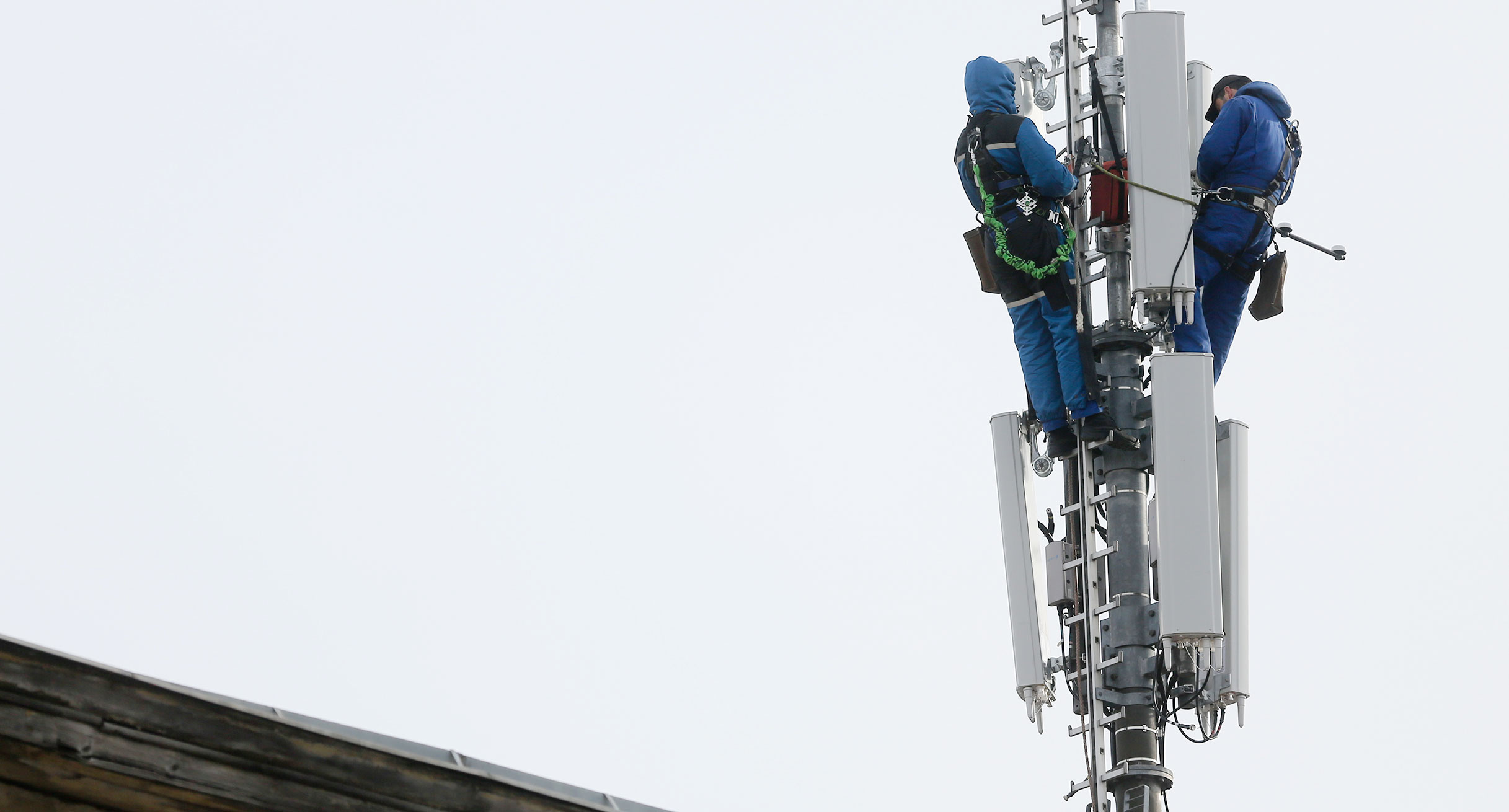 In luftiger Höhe werden Arbeiten an einem Mobilfunkmast vorgenommen.']