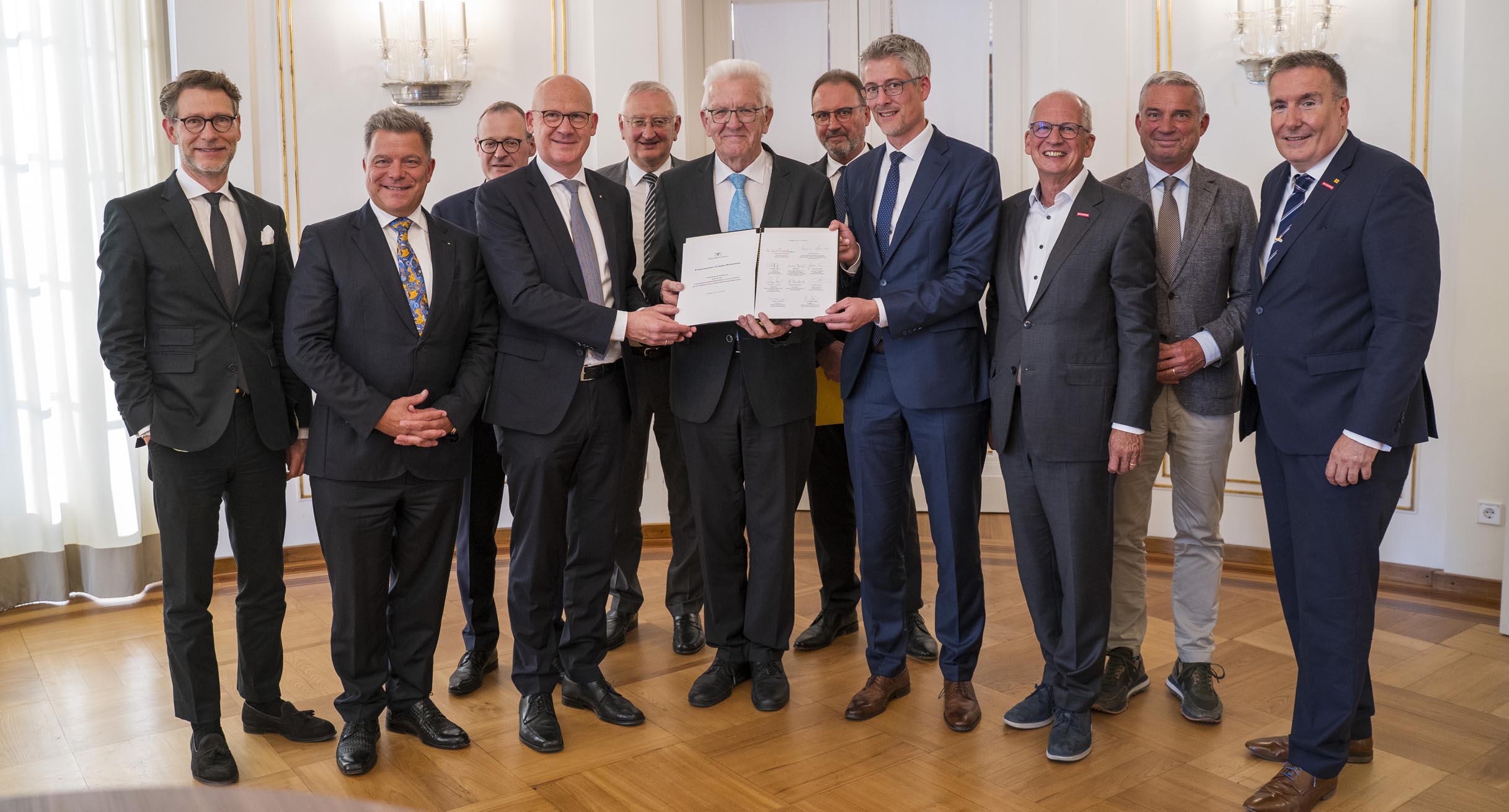 Ministerpräsident Winfried Kretschmann (Mitte), Innenminister Thomas Strobl (zweiter von rechts) und Staatsminister Dr. Florian Stegmann (links) mit Vertretern der Kommunalen Landesverbände sowie von Wirtschafts- und Finanzverbänden nach der Unterzeichnung der gemeinsamen Entlastungsallianz für Baden-Württemberg im Runden Saal der Villa Reitzenstein in Stuttgart.']