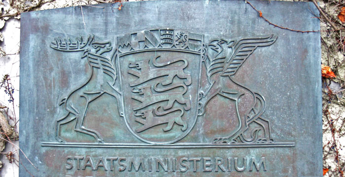 Stilisiertes Großes Landeswappen auf einer Bronzetafel vor dem Staatsministerium.