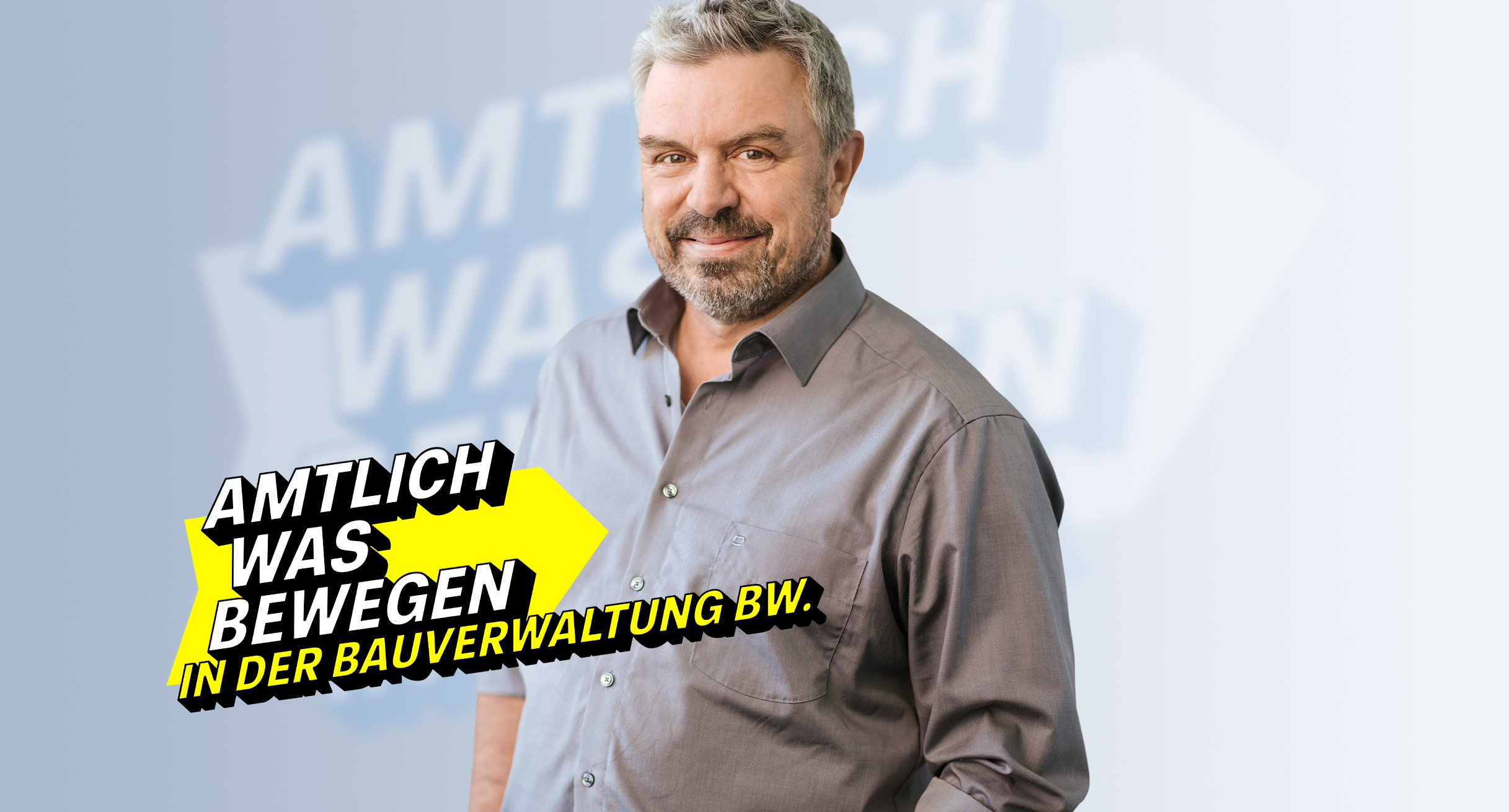 Lächelnder Ingenieur im grauen Hemd, repräsentiert Engagement in der Bauverwaltung BW.