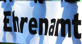 Jugendliche halten ein Banner mit der Aufschrift «Ehrenamt» in den Händen.