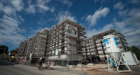 Bauarbeiter laufen in Stuttgart an Neubauten der Stuttgarter Wohnungs- und St&auml;dtebaugesellschaft mbH (SWSG) vorbei. (Foto: &copy; dpa)