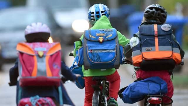 Kinder sind auf einer Stra&szlig;e mit dem Fahrrad unterwegs zur Schule. (Foto: &copy; dpa)