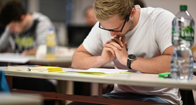 Abiturienten lesen sich kurz vor Beginn der Pr&uuml;fung die Abituraufgaben im Fach Deutsch durch.