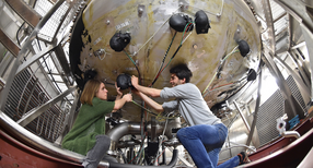 Mitarbeiter des Bereichs der atmosph&auml;rischen Aerosolforschung beim Karlsruher Institut f&uuml;r Technologie (KIT) arbeiten im Wolkenlabor an der Anlage f&uuml;r Aerosol Interaktionen und Dynamik in der Atmosph&auml;re (AIDA). (Foto: dpa)