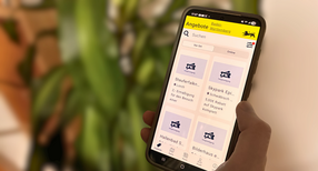Eine Person h&auml;lt ein Smartphone in der Hand. Auf dem Display sieht man die Startseite der Ehrenamtskarten-App f&uuml;r Baden-W&uuml;rttemberg.