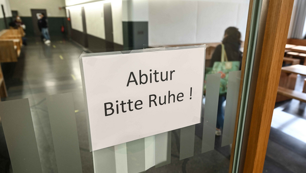 Eine Abiturienten des Spohn-Gymnasiums läuft an einem Schild mit der Aufschrift „Abitur - Bitte Ruhe!“ vorbei.