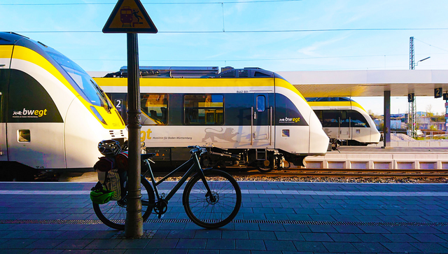 An einem Bahnhof stehen versetzt nebeneinander drei verschiedene Züge.