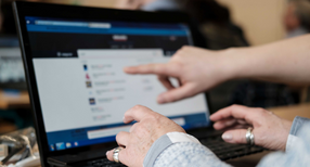 Eine &auml;ltere Dame lernt die Bedienung eines Computers.