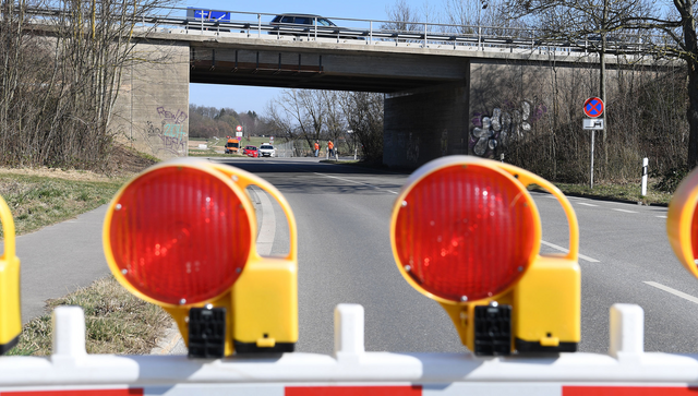 Absperrung auf einer Stra&szlig;e. Im Hintergrund eine Autobr&uuml;cke.