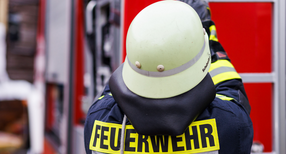 Ein Feuerwehrmann holt w&auml;hrend einer Einsatz&uuml;bung einer Freiwilligen Feuerwehr eine Leiter vom Dach eines Einsatzfahrzeugs.