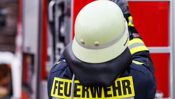 Ein Feuerwehrmann holt während einer Einsatzübung einer Freiwilligen Feuerwehr eine Leiter vom Dach eines Einsatzfahrzeugs.