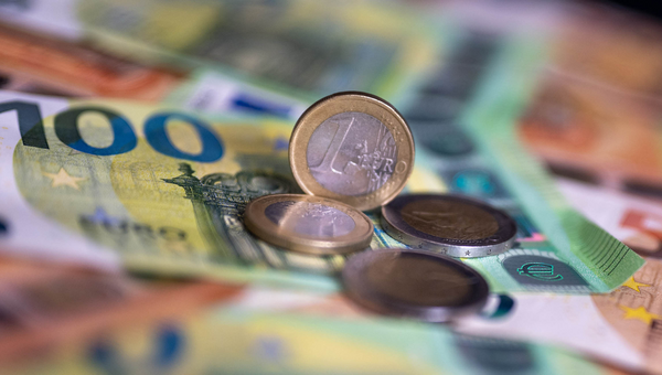 Geldscheine mit dem Wert von 100 und 50 Euro und Münzen liegen auf einem Tisch.