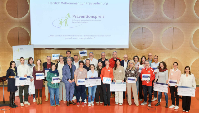 Gruppenbild auf der B&uuml;hne: Sozialminister Manne Lucha mit allen Preistr&auml;gern des Pr&auml;ventionspreises 2026