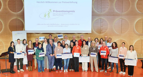 Gruppenbild auf der B&uuml;hne: Sozialminister Manne Lucha mit allen Preistr&auml;gern des Pr&auml;ventionspreises 2026