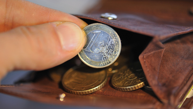 Eine Hand nimmt eine Euro-Münze aus einer Geldbörse, in der sich weitere Münzen befinden. (Foto © dpa)