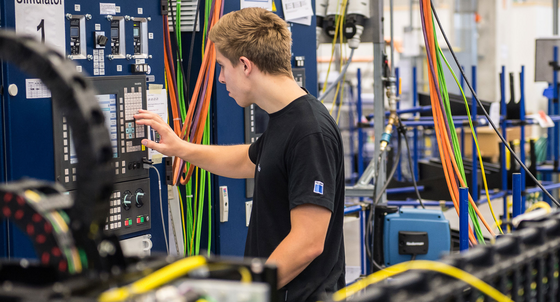 Ein Produktionstechnologe in Ausbildung arbeitet an einem Simulator für die Bewegungseinheit eines Laser. (Foto: © dpa)