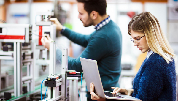 Eine Studentin und ein Student der Elektrotechnik arbeiten an einem Projekt.