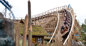 Eine Gruppe von Menschen f&auml;hrt Achterbahn in einem Erlebnispark.